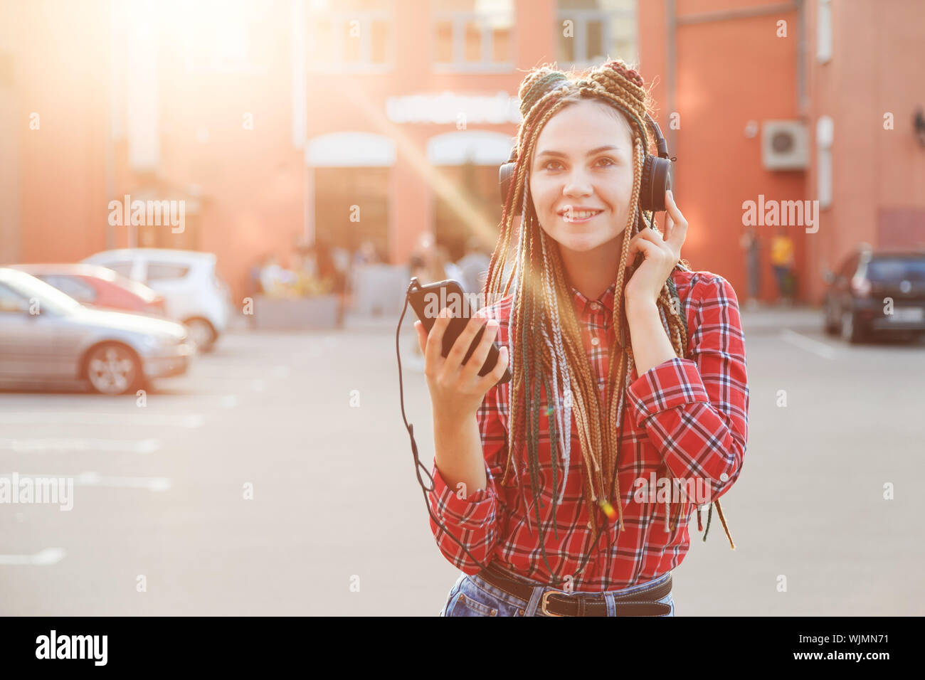 Hipster ragazza ascoltare musica con le cuffie sulla strada Foto Stock