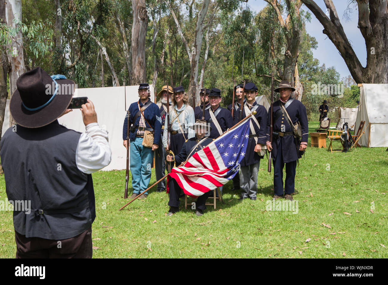 Unione parte di soldati di una guerra civile americana rievocazione storica posare per un fotografo vestito in costume e prese con una moderna smart phone. Foto Stock