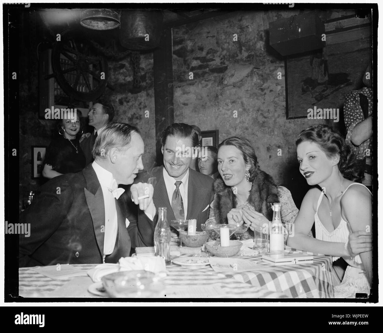 Hopkins e stelle vedi club l'apertura. Washington, 8 febbraio Washington della nuovissima supper club aperto la notte scorsa con celebrità e stelle di presenze. Qui, Hopkins, Segretario del Commercio, star di cinema Errol Flynn e la sig.ra John Hay Whitney, ricchi socialite, hanno trovato il loro modo di divertimento. Nota "pop" bottiglia sul tavolo, 2-8- 39 Foto Stock