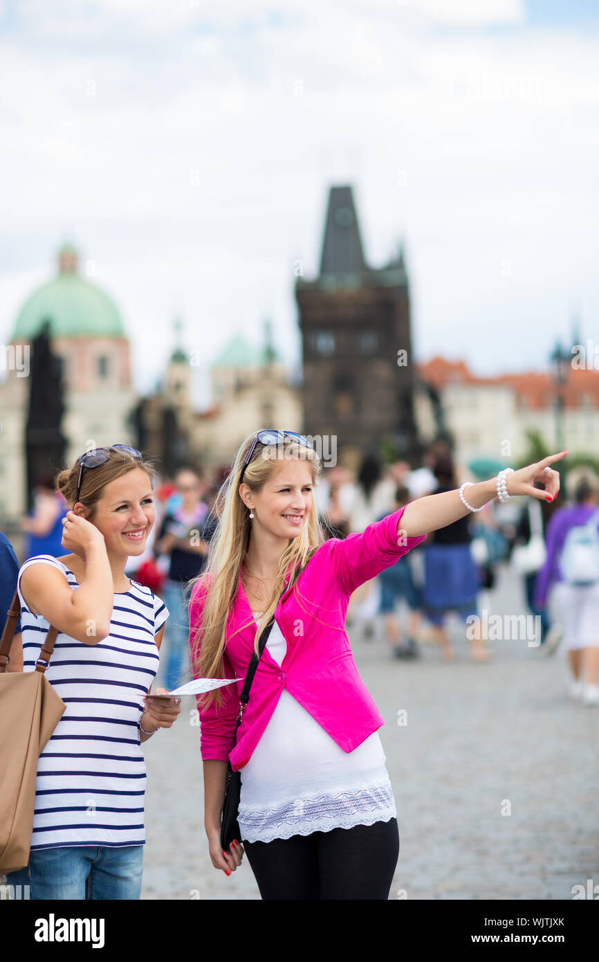 Due turisti femmina camminando lungo il ponte Carlo durante la visita a Praga, la storica capitale della Repubblica ceca Foto Stock