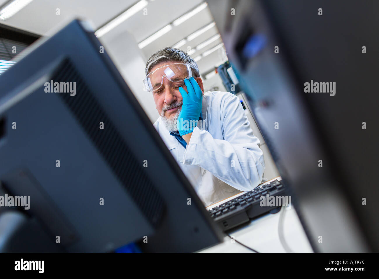 Maschio senior researcher di effettuare attività di ricerca scientifica in un laboratorio - sonnecchia via per un po' di tempo in un modo divertente (SHALLOW DOF; dai toni di colore immagine) Foto Stock