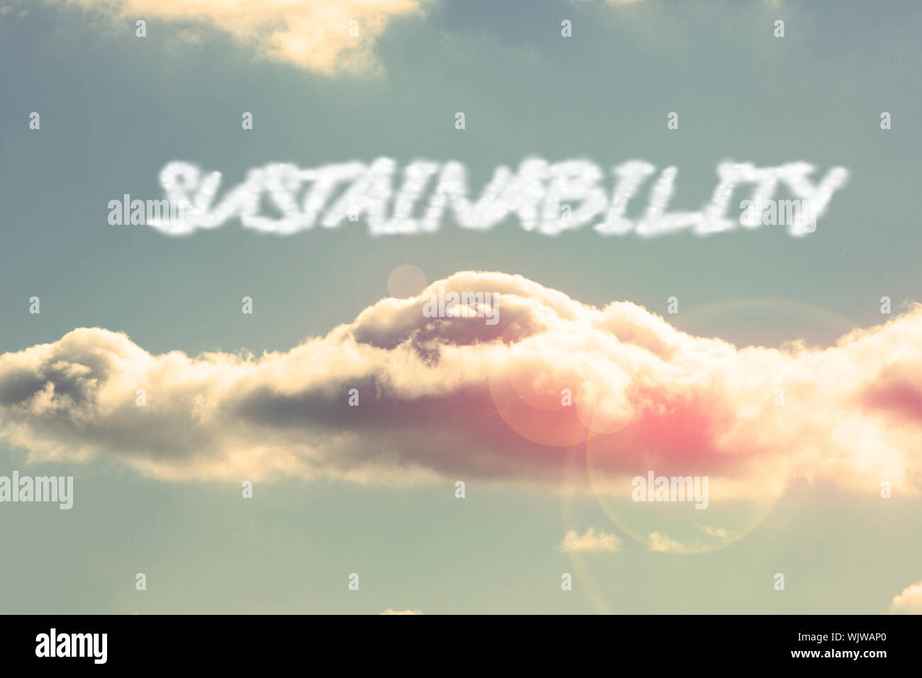 La parola sostenibilità brillante contro il cielo blu con nuvole Foto Stock