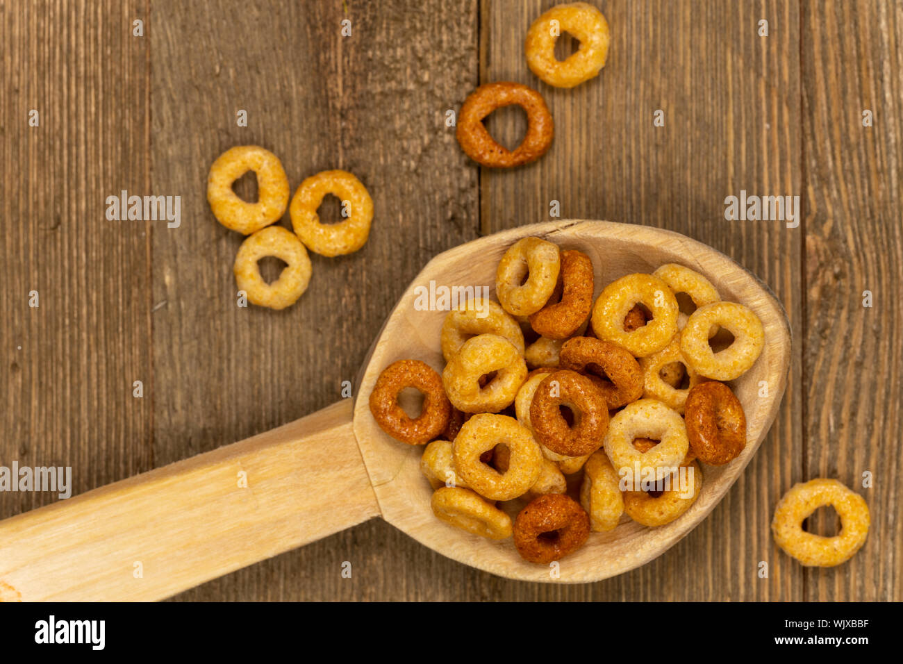 Close-up di texture tostato cereali di avena in un cucchiaio di legno con il fuoco selettivo. Foto Stock