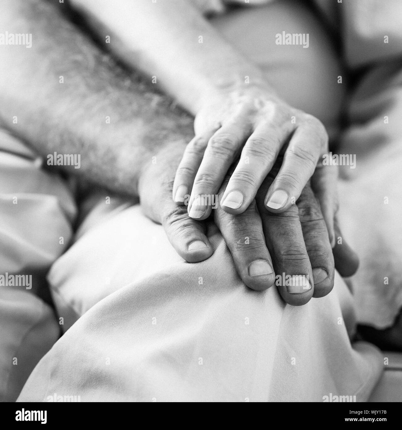Coppia senior tenendo le mani a casa nel soggiorno Foto Stock