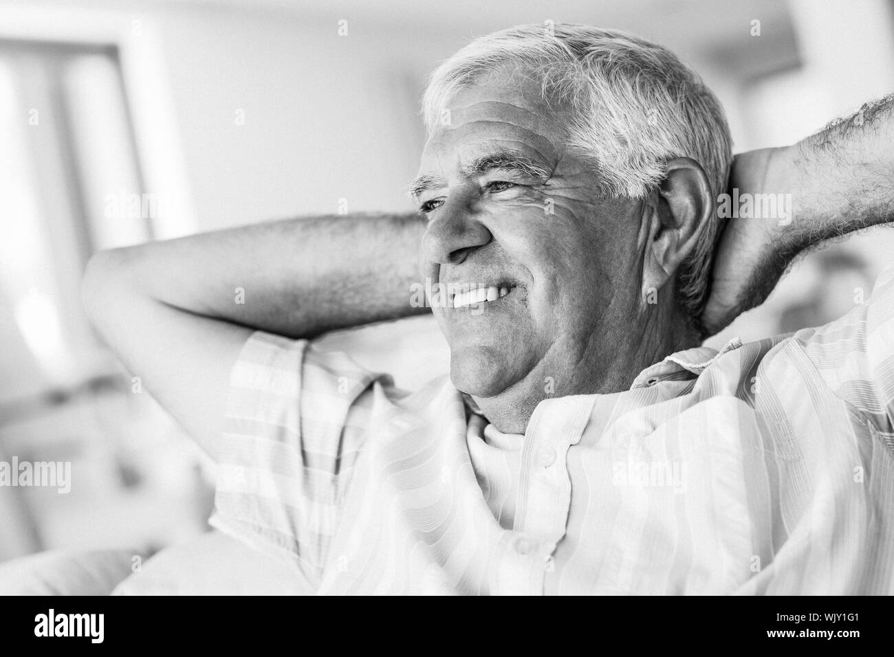 Felice l'uomo senior rilassante sul divano di casa in soggiorno Foto Stock