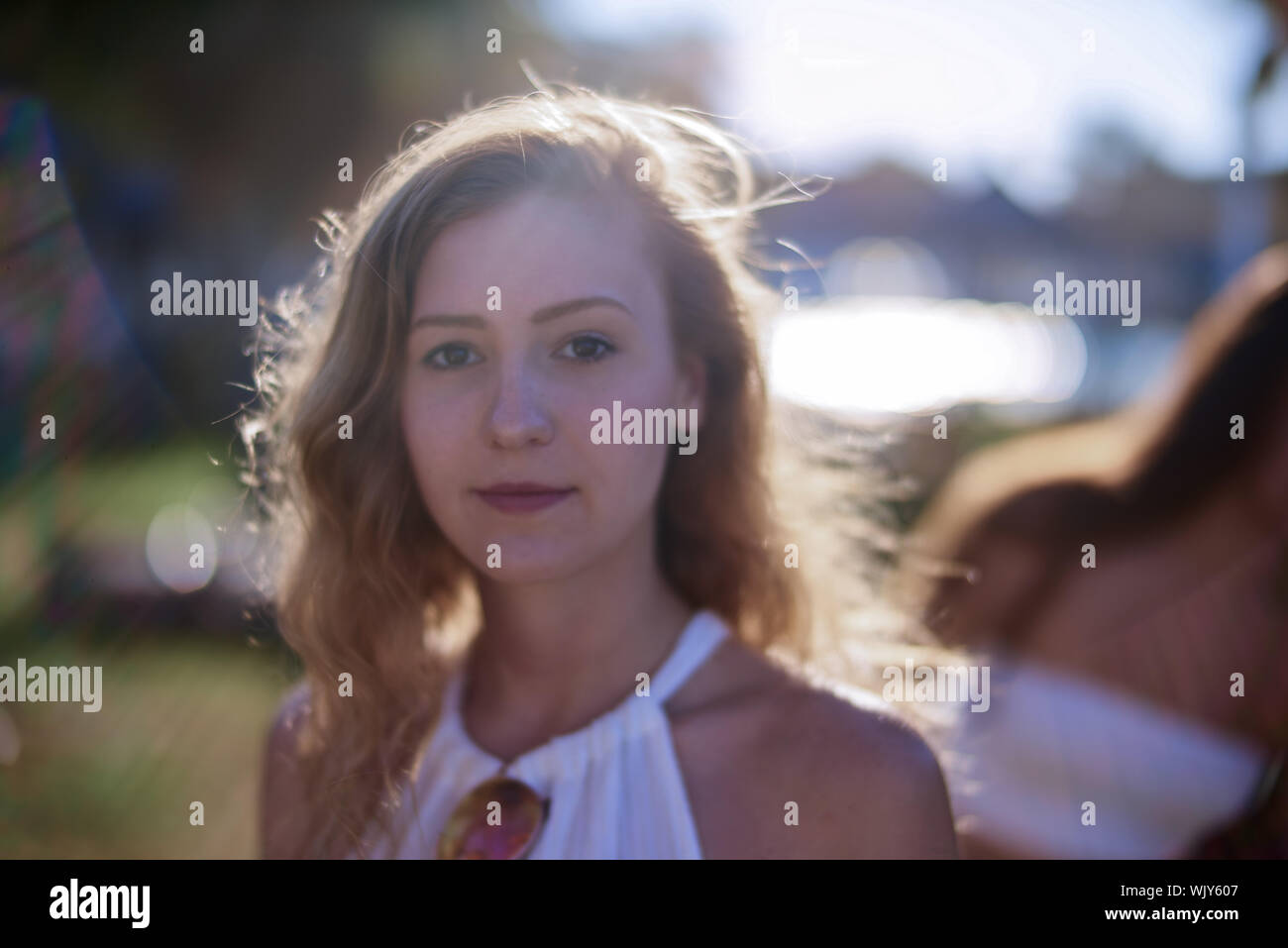 Ritratto di giovane donna in piedi all'aperto durante la giornata di sole Foto Stock