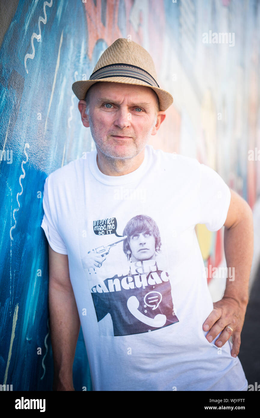 Berlino, Germania. Il 22 agosto, 2019. Jim Avignon, artista, sorge di fronte al suo lavoro presso la East Side Gallery. Quasi trenta anni fa, gli artisti stessi immortalate qui e reinterpretato il più lungo la restante sezione del muro di Berlino con le loro opere d'arte. (Per "Wall artista Avignone: East Side Gallery assegnato di nuovo ogni anno") Credito: Arne Immanuel Bänsch/dpa/Alamy Live News Foto Stock