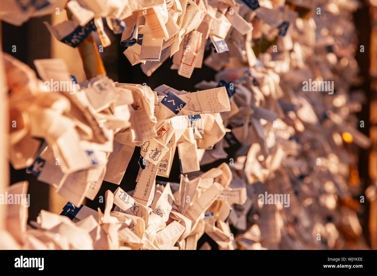 Dicembre 3, 2018 Yamagata, Giappone - Giappone Omikuji fortune le strisce di carta di serraggio sulla corda sotto la luce del tramonto di svasatura Yamadera al tempio. Foto Stock