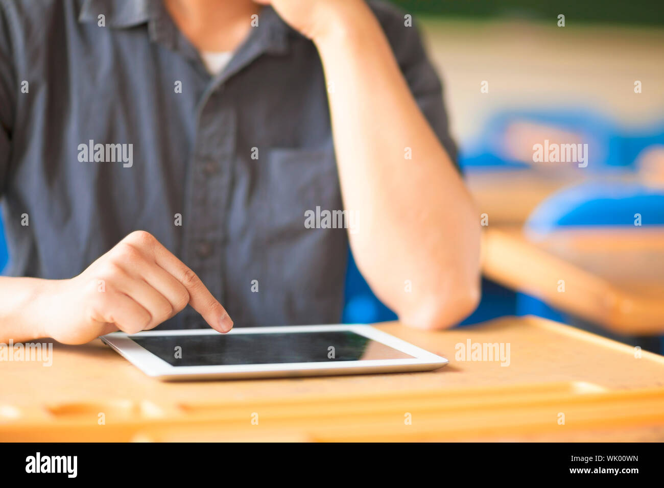 Giovane uomo utilizzando un tablet o ipad in una classe Foto Stock