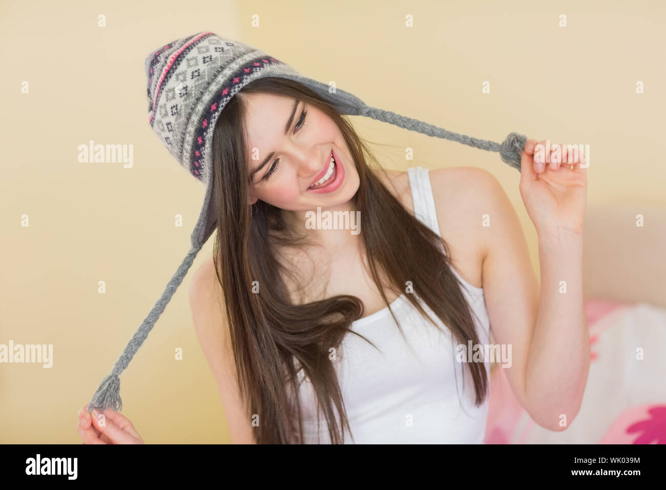 Silly Pretty girl cercando su un cappello di lana Foto Stock