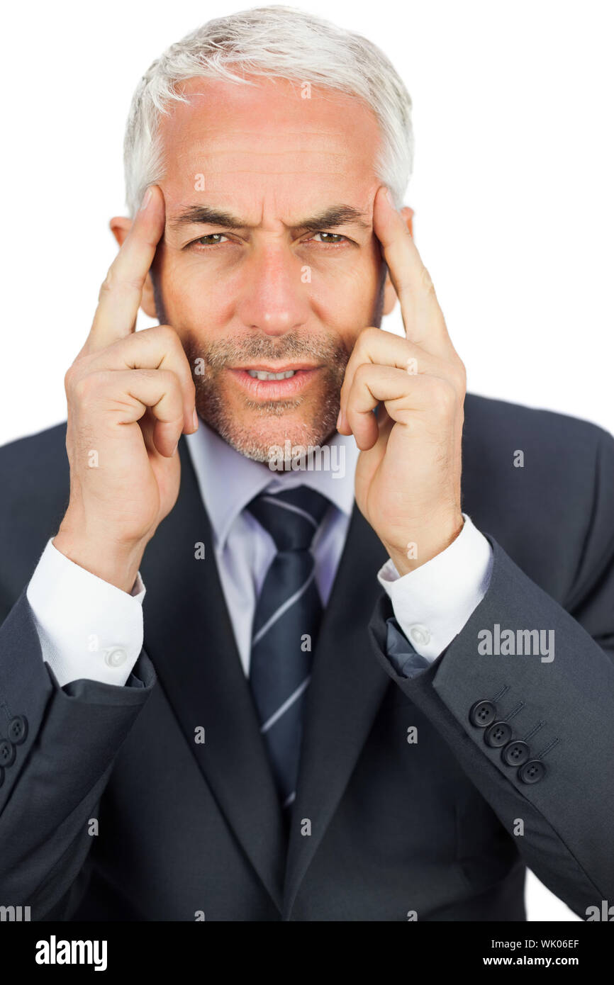 Imprenditore concentrato tenendo la sua templi Foto Stock