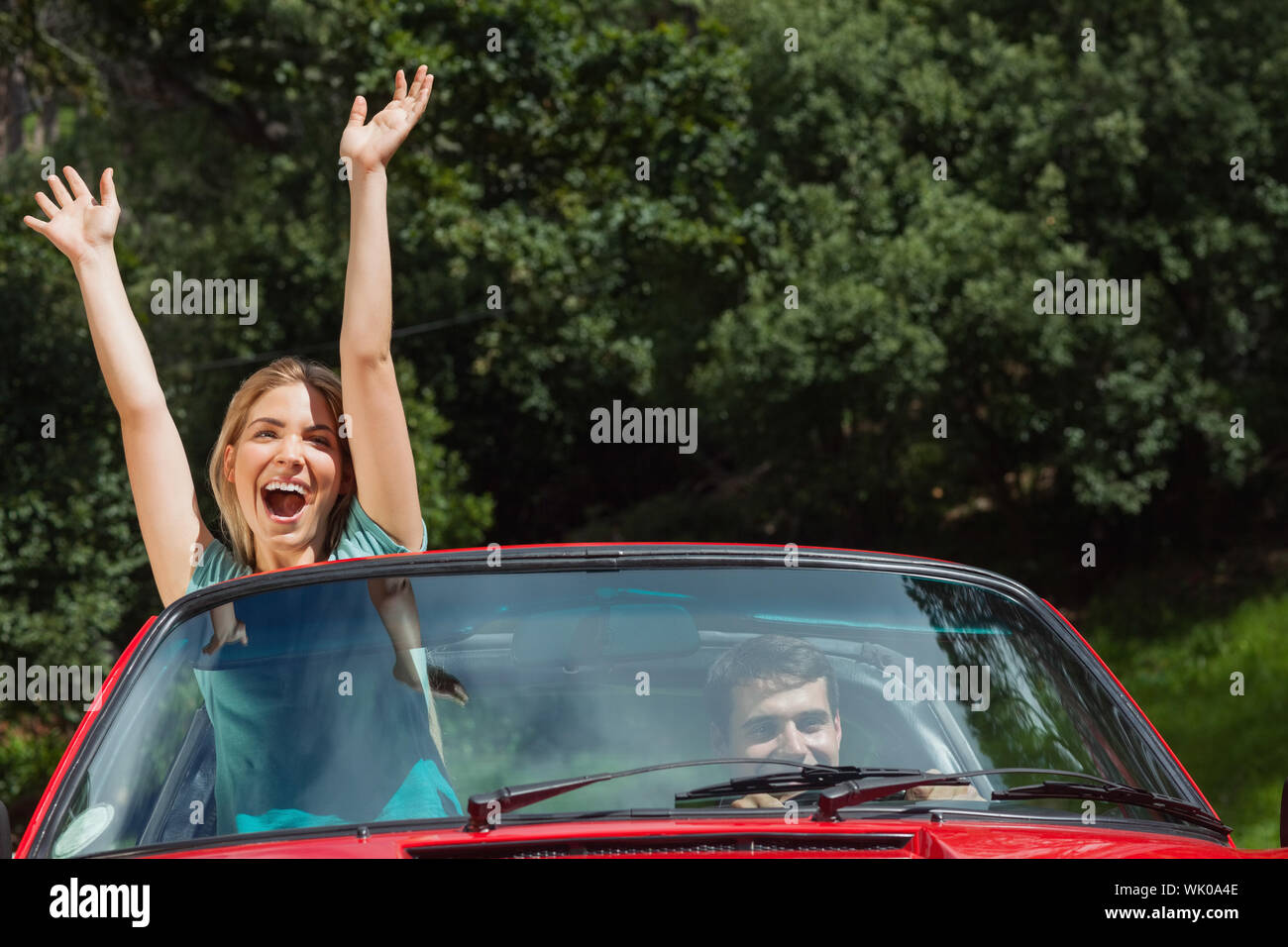 Coppia felice avendo divertimento loro rossa cabriolet Foto Stock