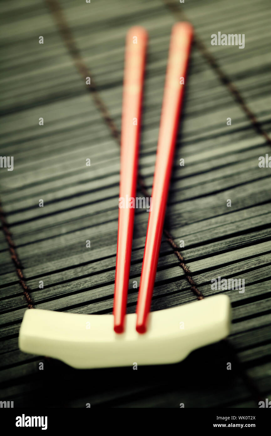 Bacchette di colore rosso su un bambù che serve mat Foto Stock