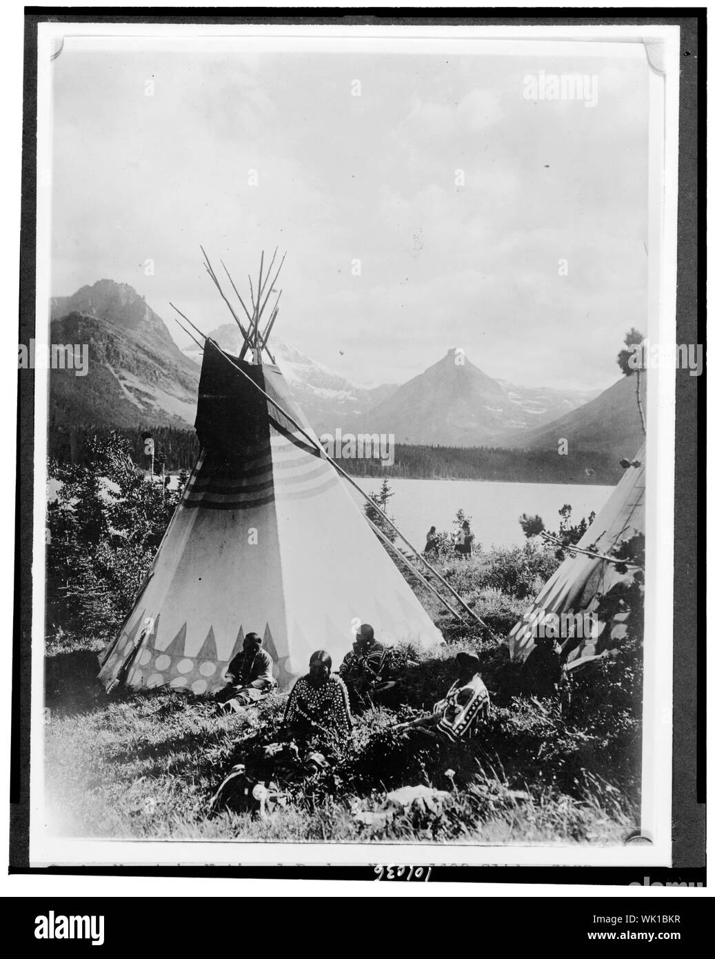 Indiano con due tepees accanto a un lago nel Parco Nazionale delle Montagne Rocciose, Colorado Foto Stock