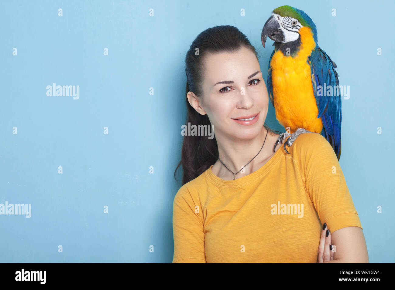 Ritratto di una giovane donna con il suo domestico pappagallo ara Foto  stock - Alamy