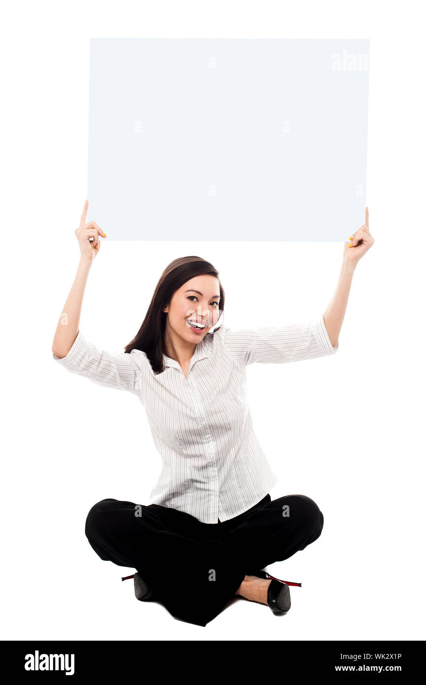 Giovane donna tenendo la scheda annunci sopra la sua testa Foto Stock