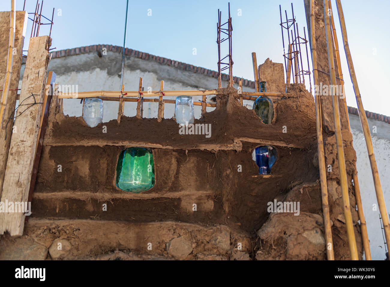 Chiudere la fotografia di un muro fatto di fango e di bottiglie di vetro, all'aperto in una giornata di sole Foto Stock