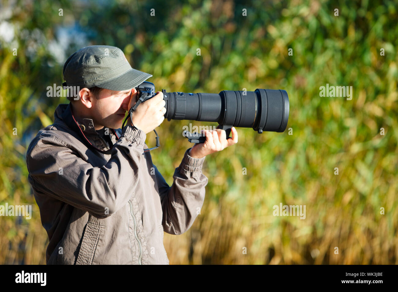 Giovane fotografo di natura con il prelievo di foto con teleobiettivo Foto Stock
