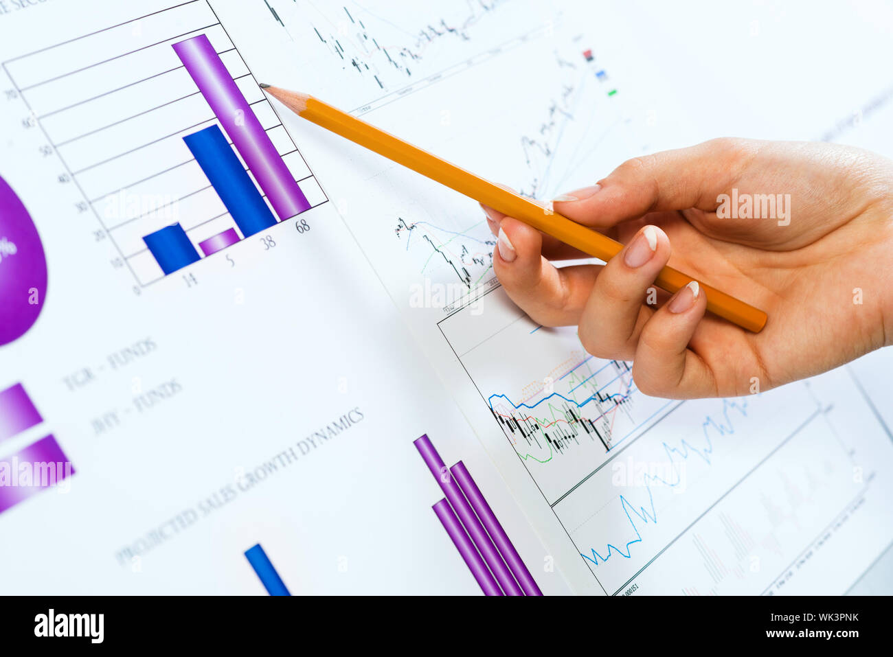 Femmina di puntamento a mano matita su grafici finanziari Foto Stock