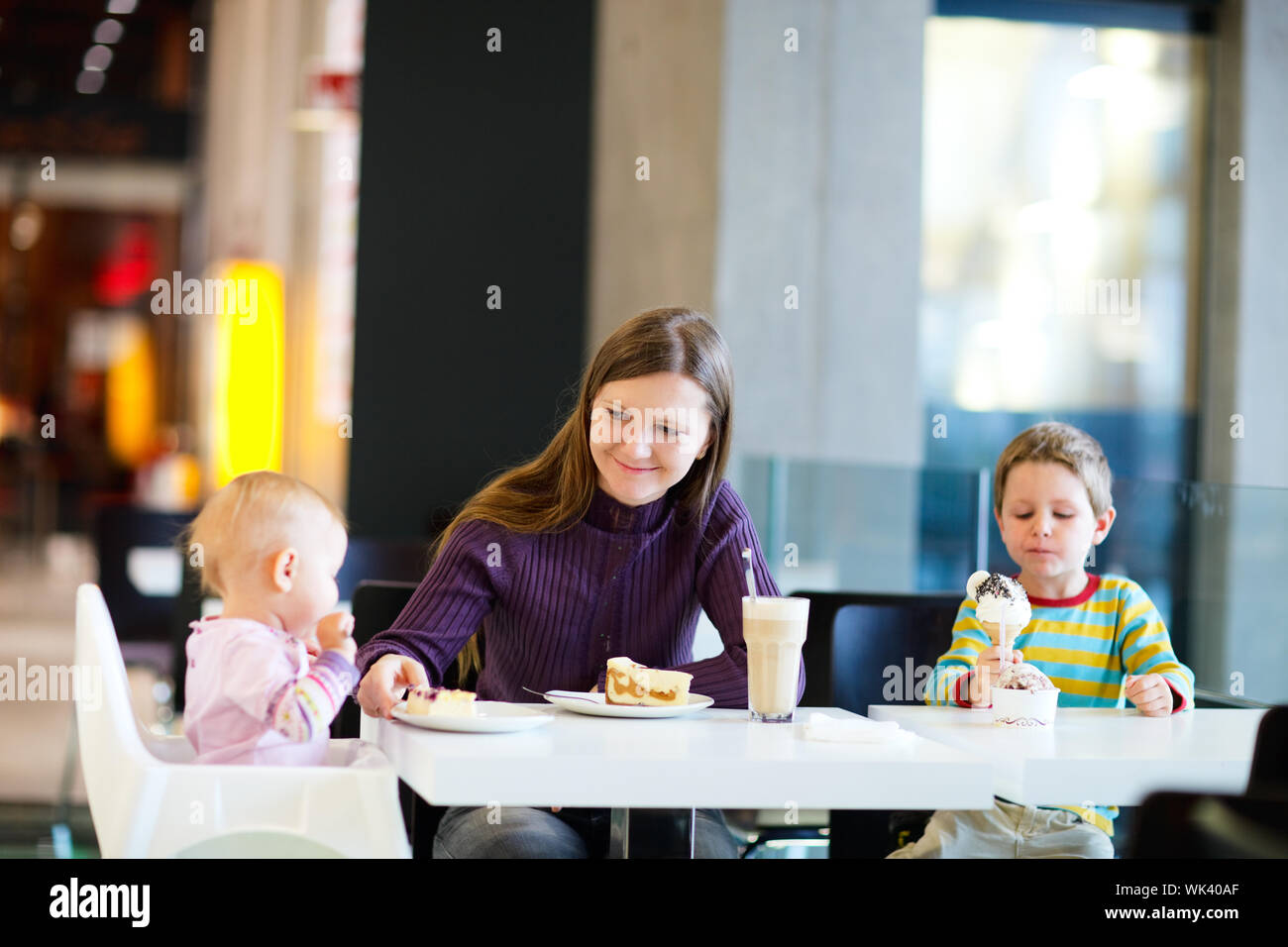 Giovane madre con due bambini godendo di pasto presso il cafe Foto Stock