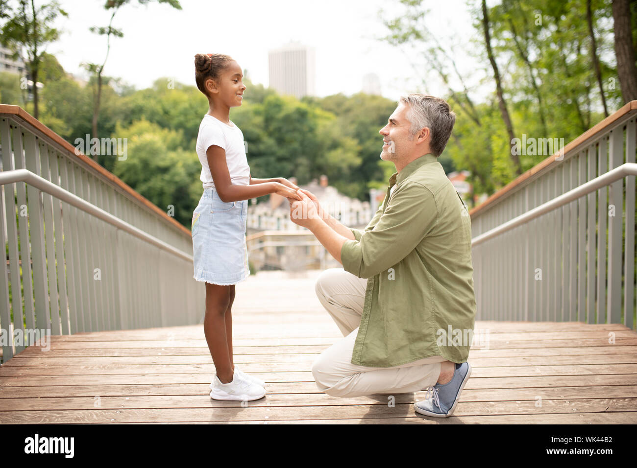 Allegro figlia sorridente mentre si parla con il papà Foto Stock