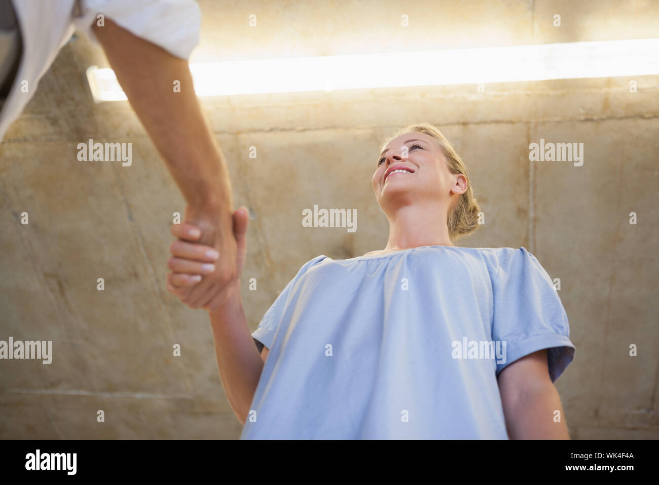 Business casual donna stringono le mani con qualcuno in ufficio Foto Stock