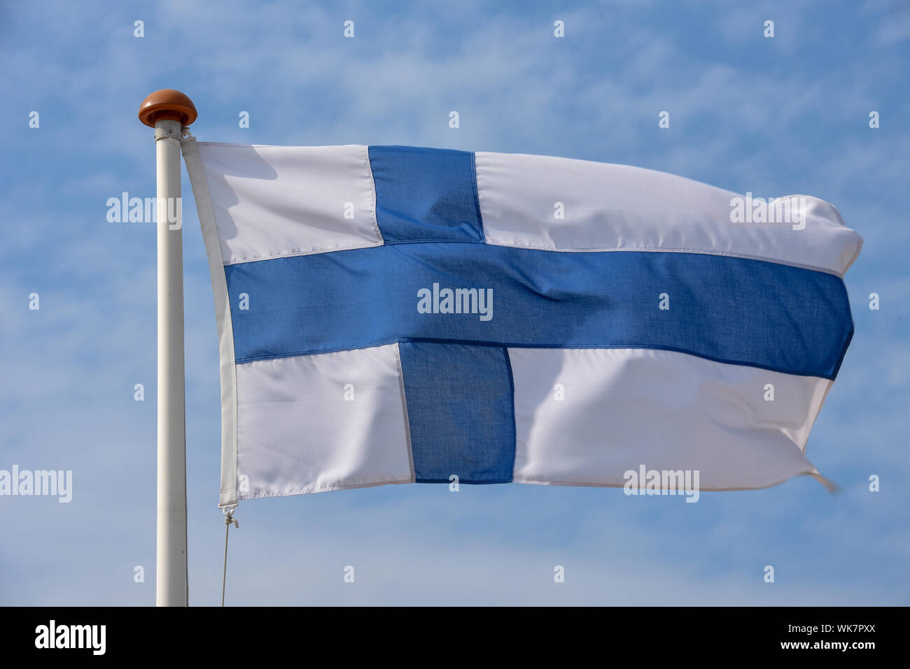 Bandiera finlandese sventolare sul vento contro il cielo blu Foto Stock