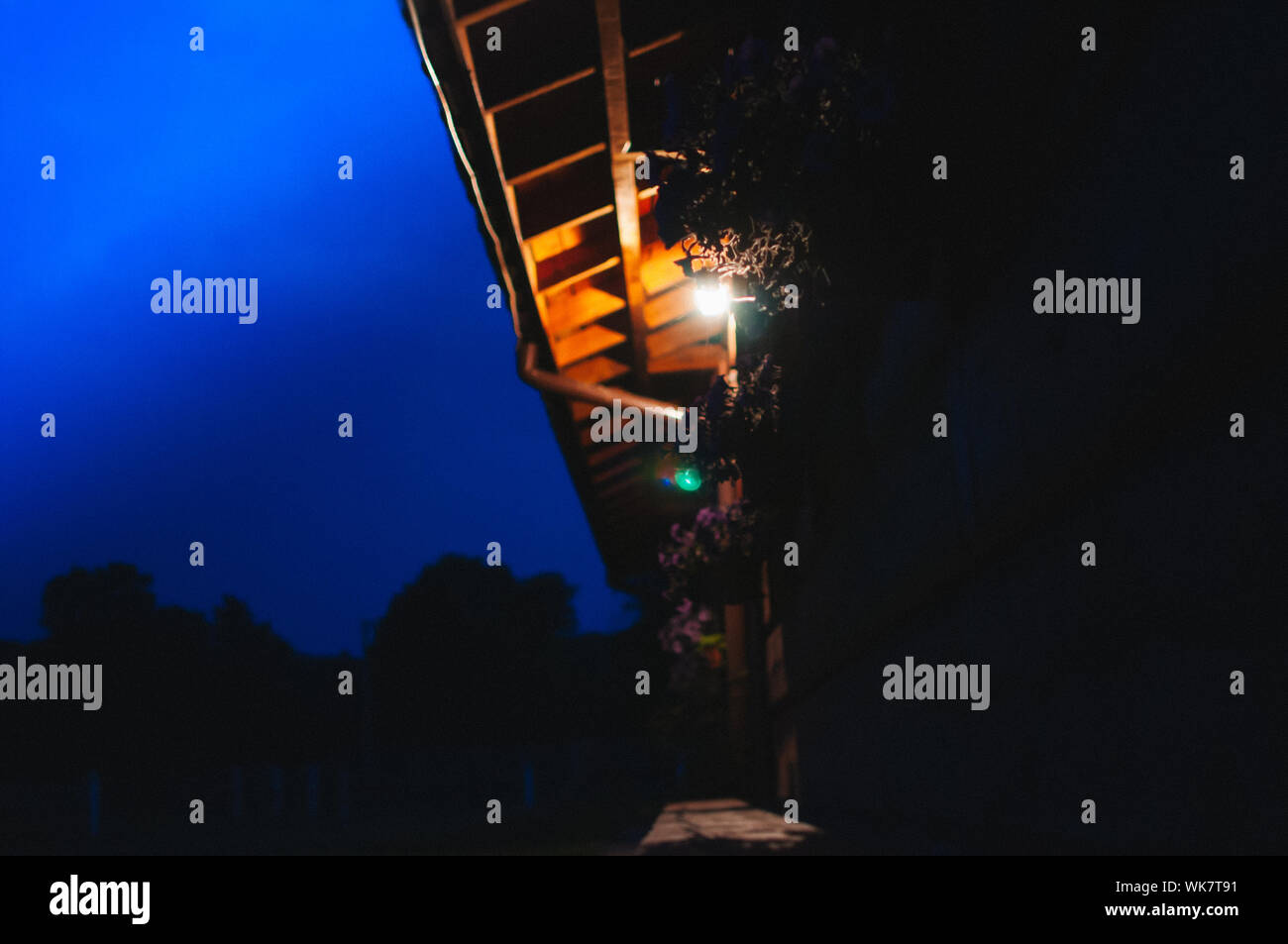 Vista della cabina in legno illuminato dalla lampada al crepuscolo Foto Stock