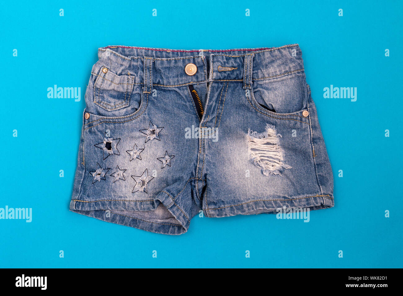 Strappato eleganti jeans corti su uno sfondo blu Foto Stock