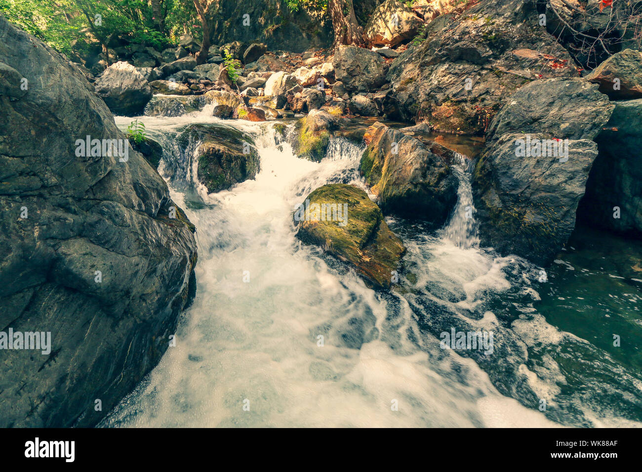 Cascata di acqua che fluisce attraverso le grandi rocce in foresta Kazdagi (Monte Ida) in Canakkale, Turchia. Le grandi rocce in primo piano. Foto Stock