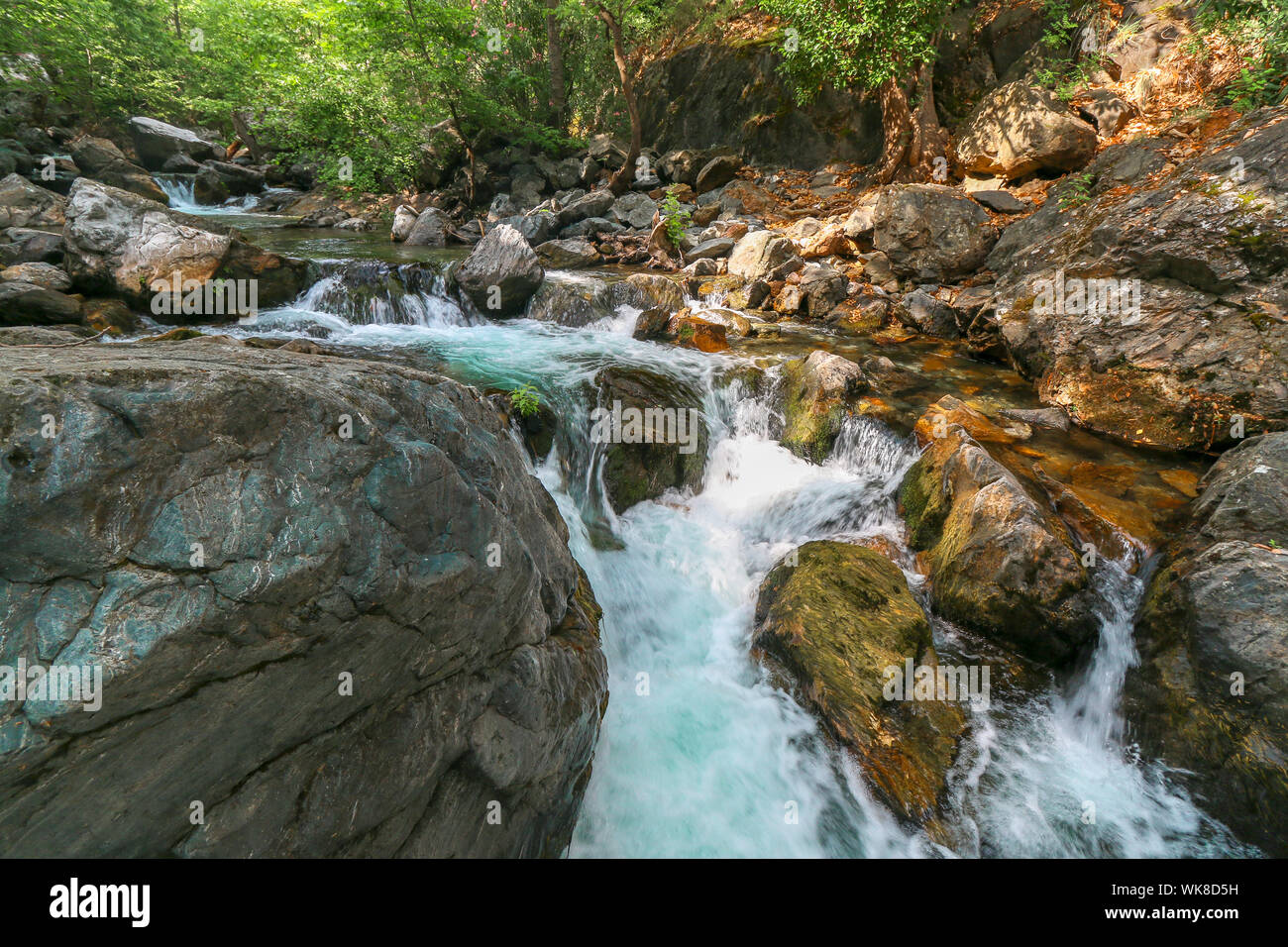 Cascata di acqua che fluisce attraverso le grandi rocce in foresta Kazdagi (Monte Ida) in Canakkale, Turchia. Inquadratura orizzontale e le grandi rocce in primo piano. Foto Stock