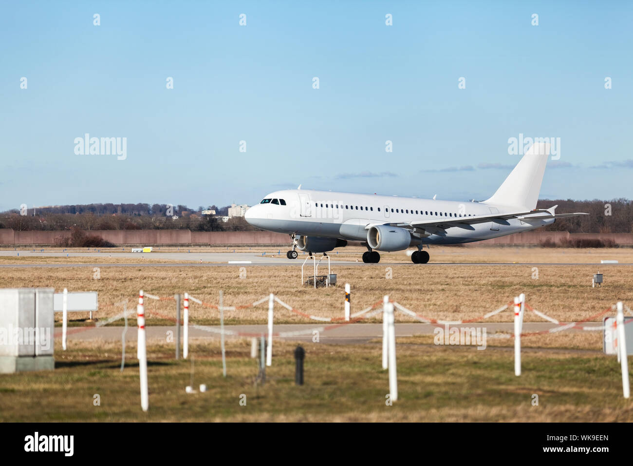 Aereo di linea di passeggeri di decollare in un aeroporto chiaro di sollevamento della pista di fronte al terminal, vista laterale Foto Stock