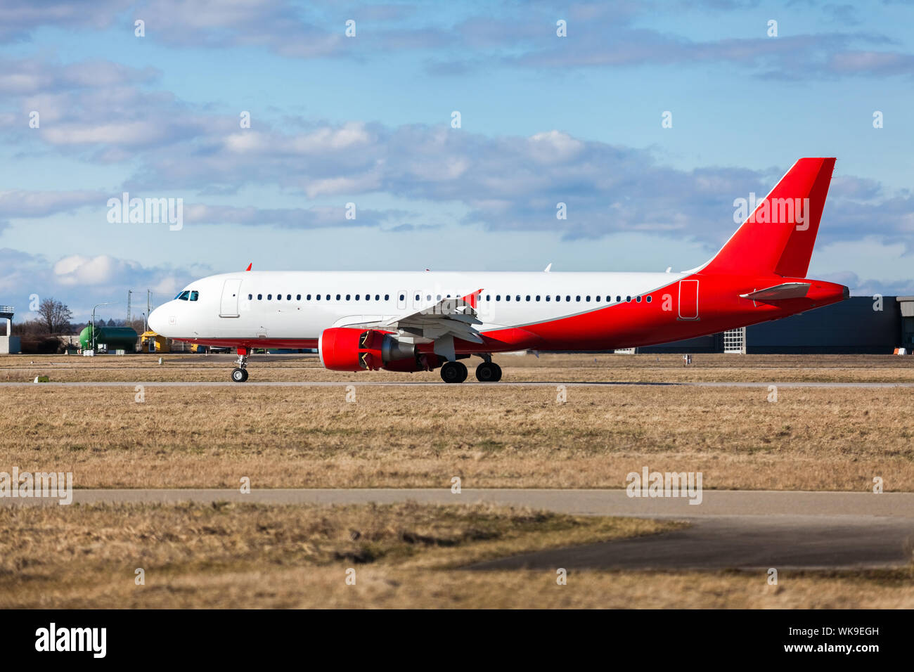 Aereo di linea di passeggeri di decollare in un aeroporto chiaro di sollevamento della pista di fronte al terminal, vista laterale Foto Stock