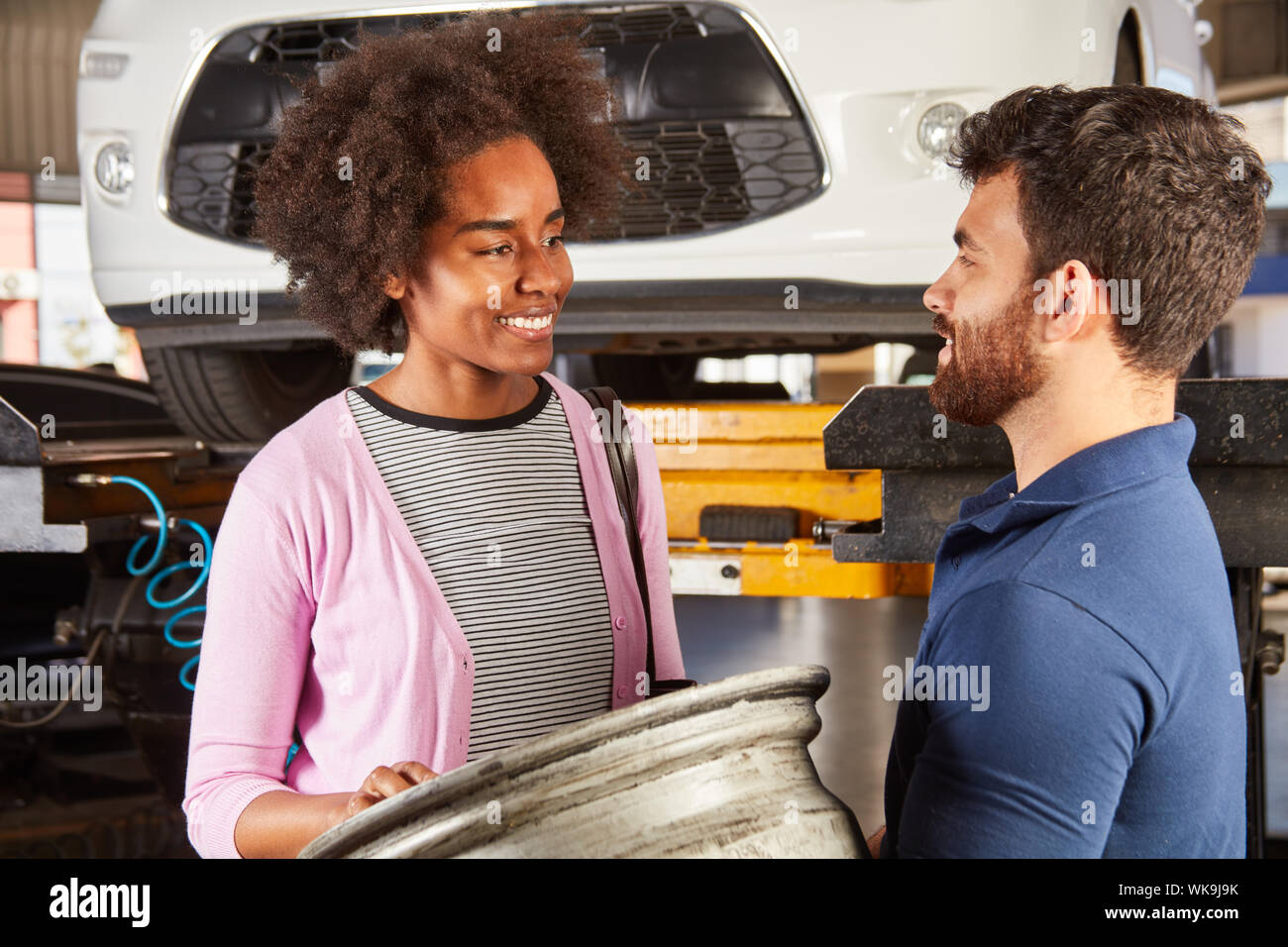 Clienti africani e meccanico con la rottura di un cerchione ruota Foto Stock
