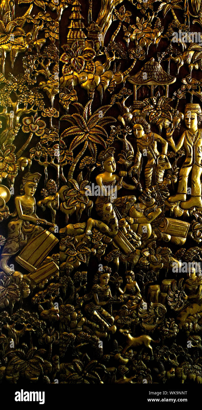 Scene scolpite in una tradizionale porta di legno Balinese e dipinte d'oro. Foto Stock