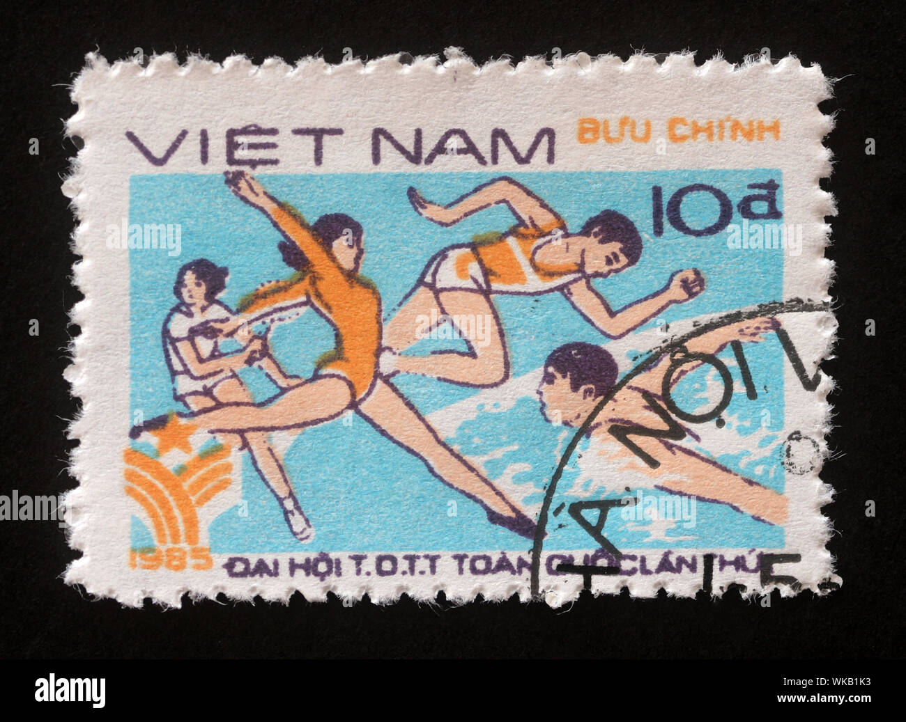 Timbro stampato in Vietnam mostra la ginnastica, la corsa e il nuoto, primo national sports festival, circa 1985. Foto Stock