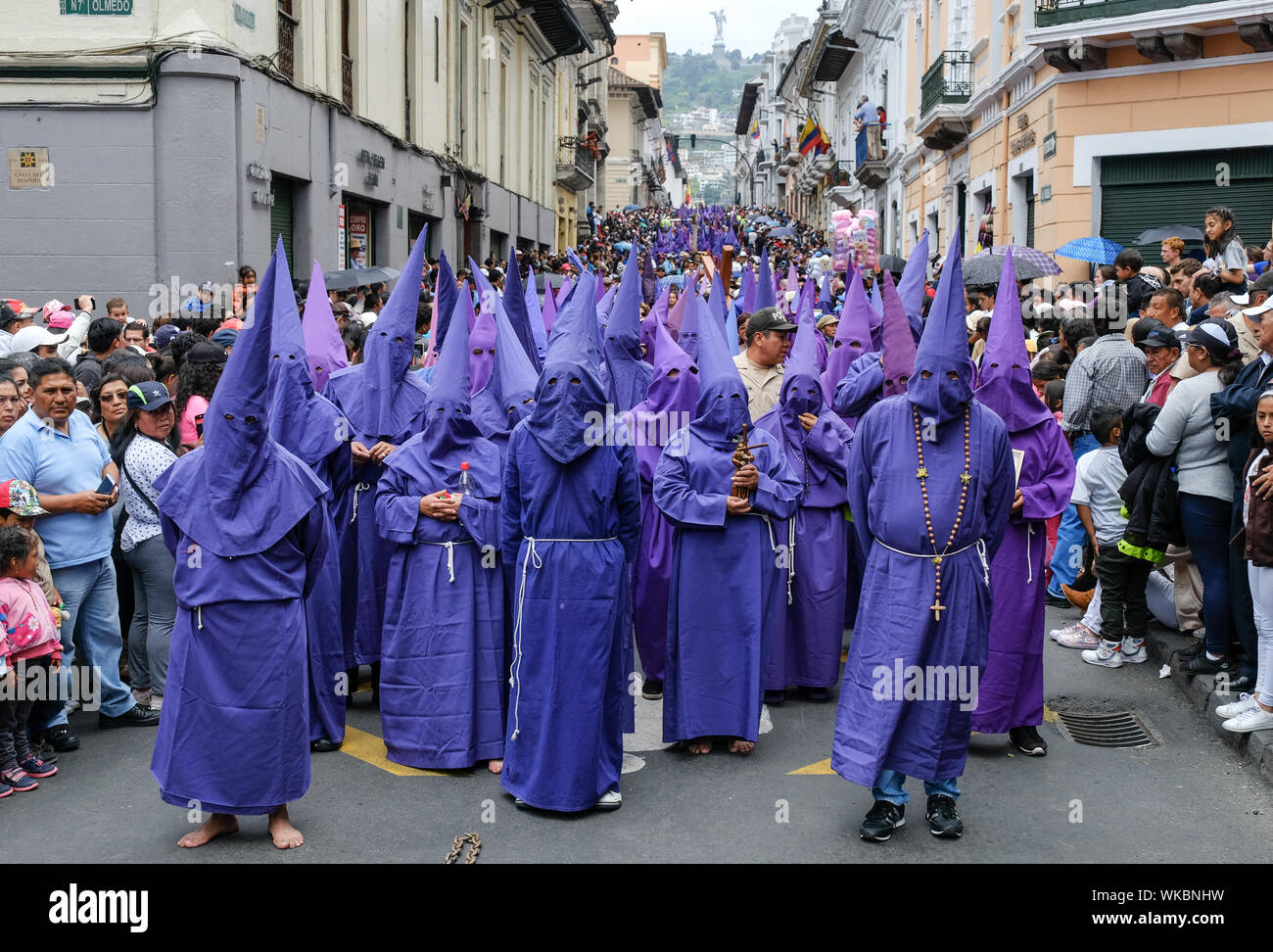 Il cucuruchos dell Ecuador a piedi le storiche strade di Quito nel loro colorate vesti di porpora e coni iconica la mattina del Venerdì Santo. Il proce Foto Stock