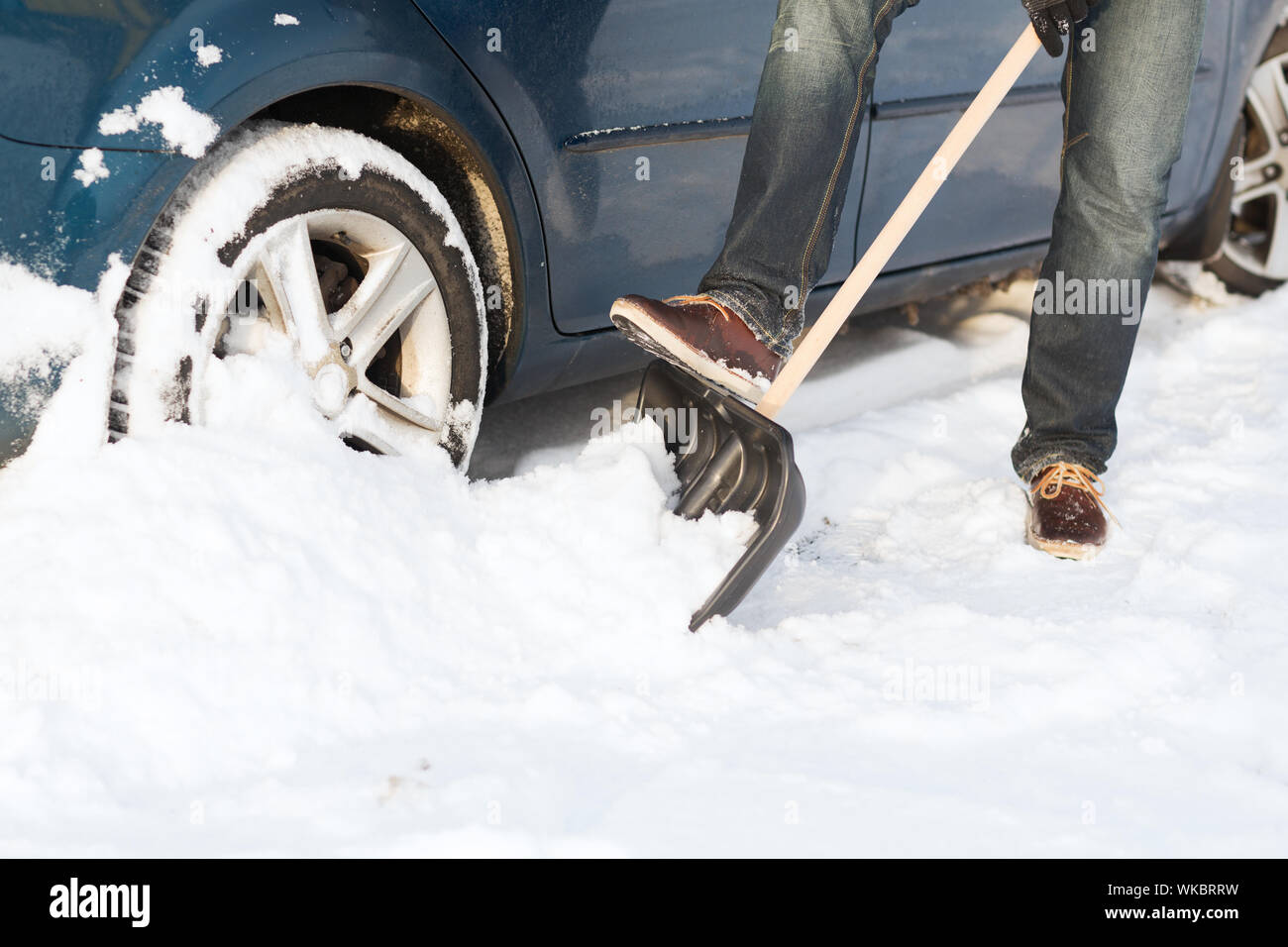 Primo piano dell'uomo scava fino bloccato in snow car Foto Stock