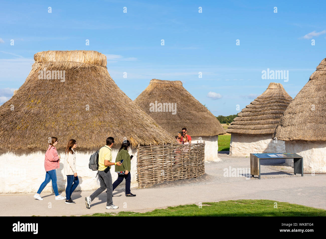 Le persone che visitano la riproduzione case neolitiche a Stonehenge visitor center Stonehenge vicino a Amesbury Wiltshire, Inghilterra UK GB Europa Foto Stock