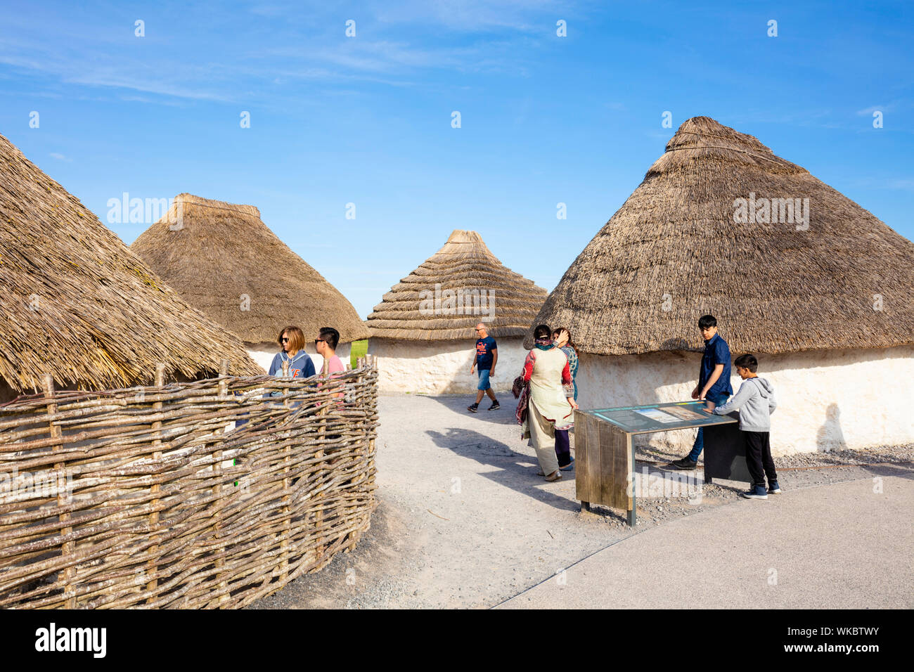 Le persone che visitano e apprendere le case neolitiche a Stonehenge visitor center Stonehenge vicino a Amesbury Wiltshire, Inghilterra UK GB Europa Foto Stock