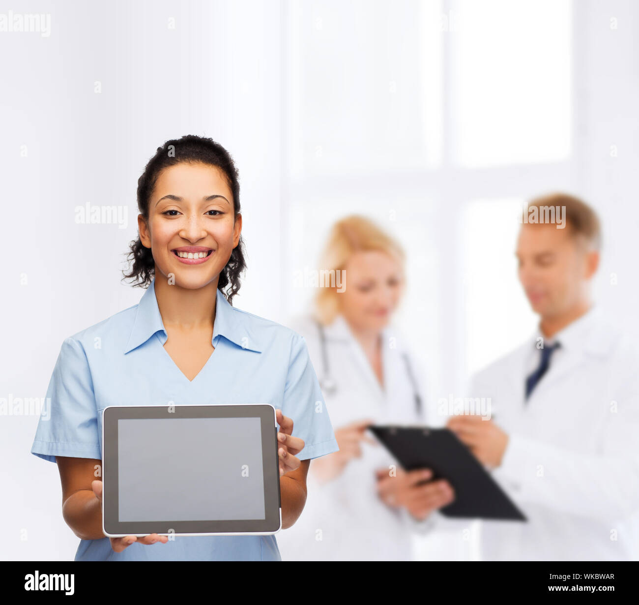 Donna sorridente medico o infermiere con il tablet pc Foto Stock