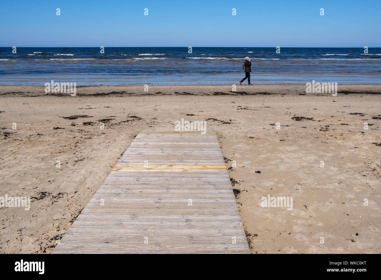 La Lettonia: Jurmala. Walker, donna, sulla spiaggia, in primavera, che si affaccia sul Mar Baltico Foto Stock