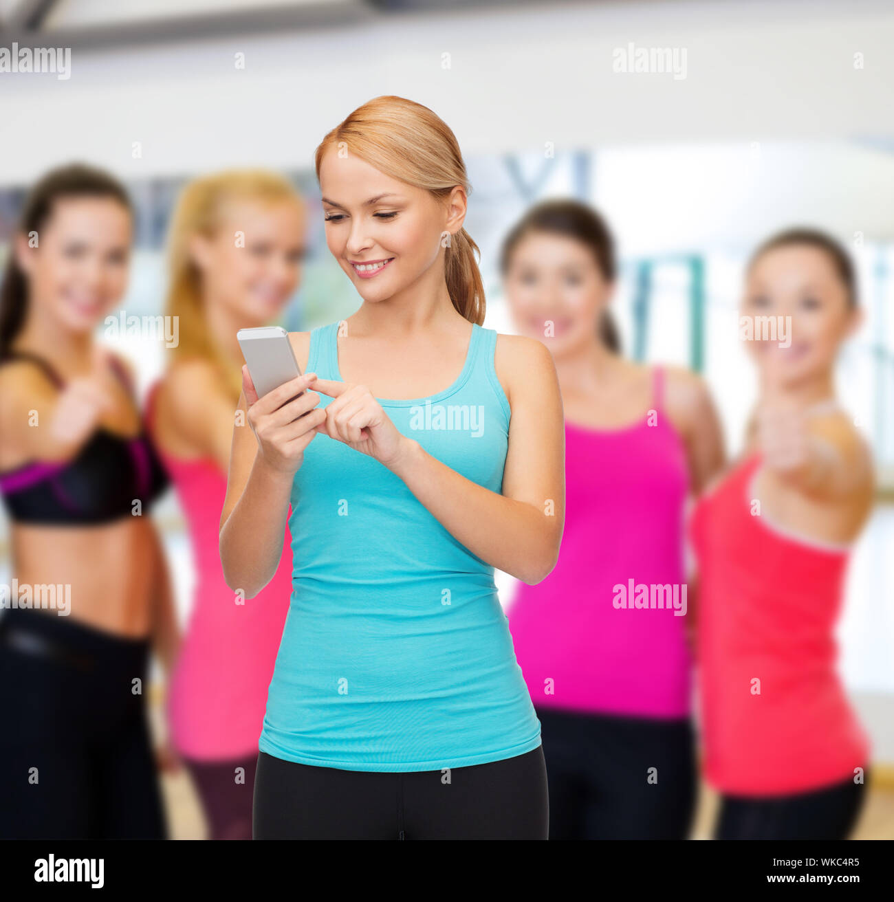 Sport, palestra, tecnologia, Internet e healthcare - sportivo da donna con lo smartphone Foto Stock