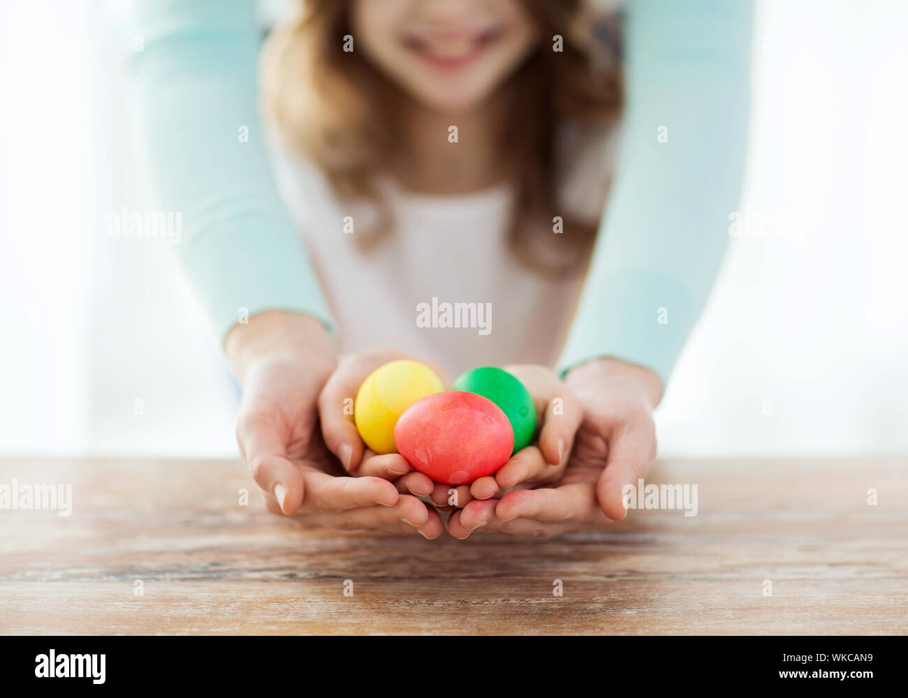 Close up della ragazza e la madre azienda uova colorate Foto Stock