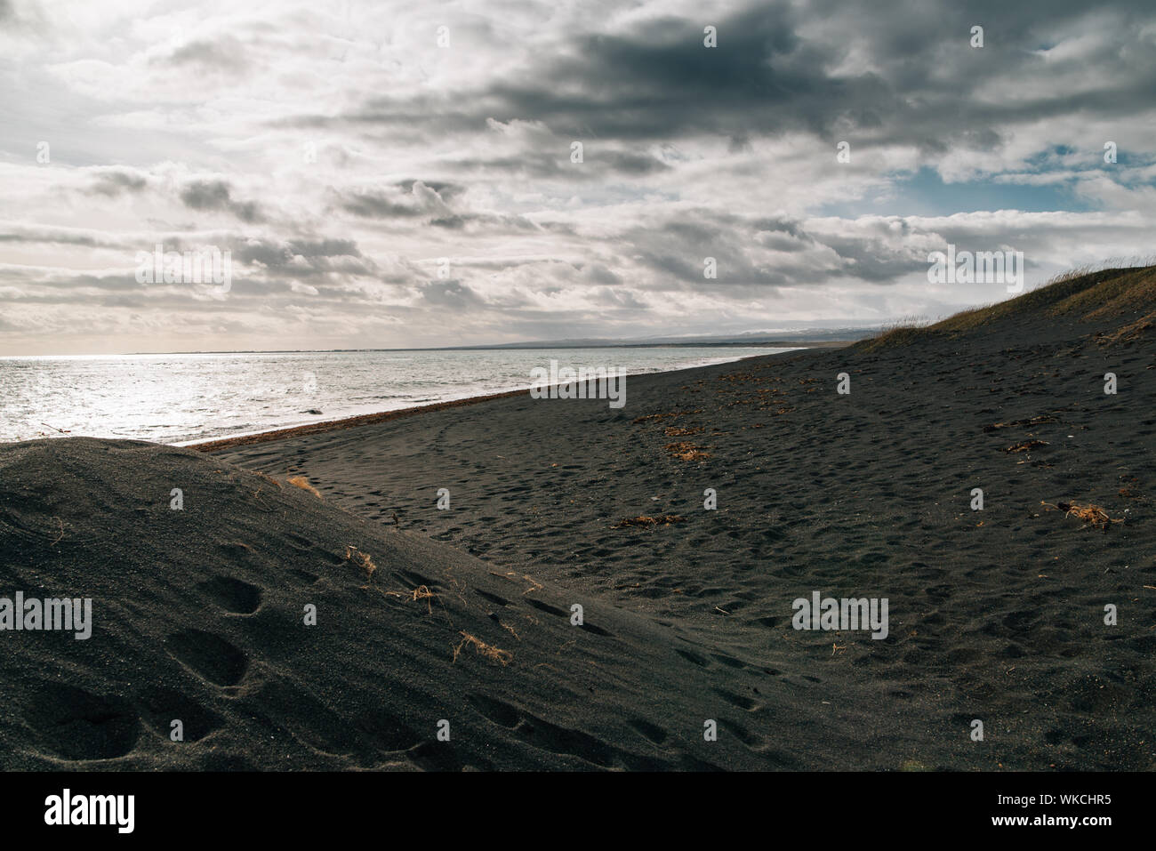 Spiaggia di sabbia nera con impronte Foto Stock