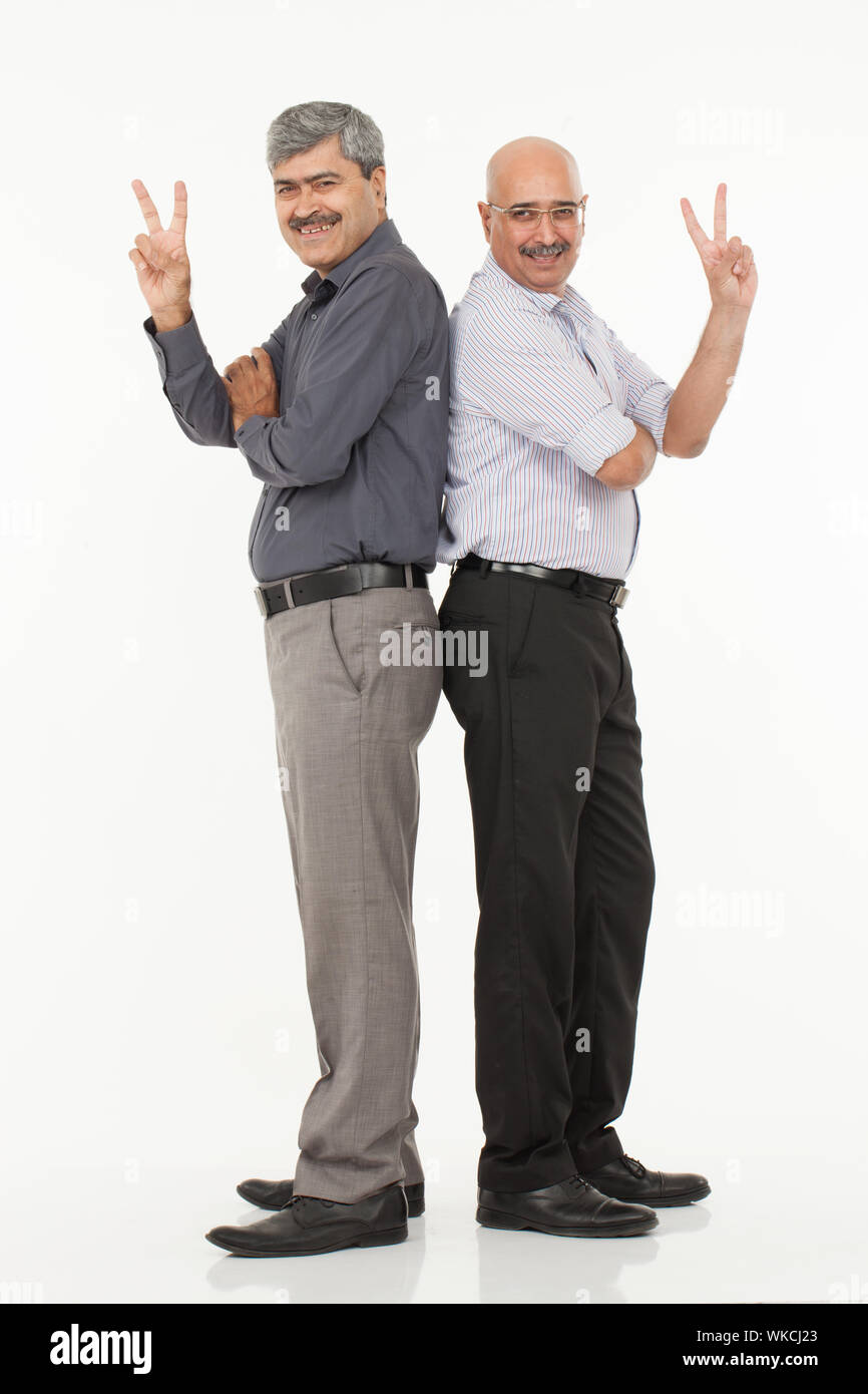 Due dirigenti aziendali che si levano in piedi indietro con la dimostrazione di V. segno Foto Stock