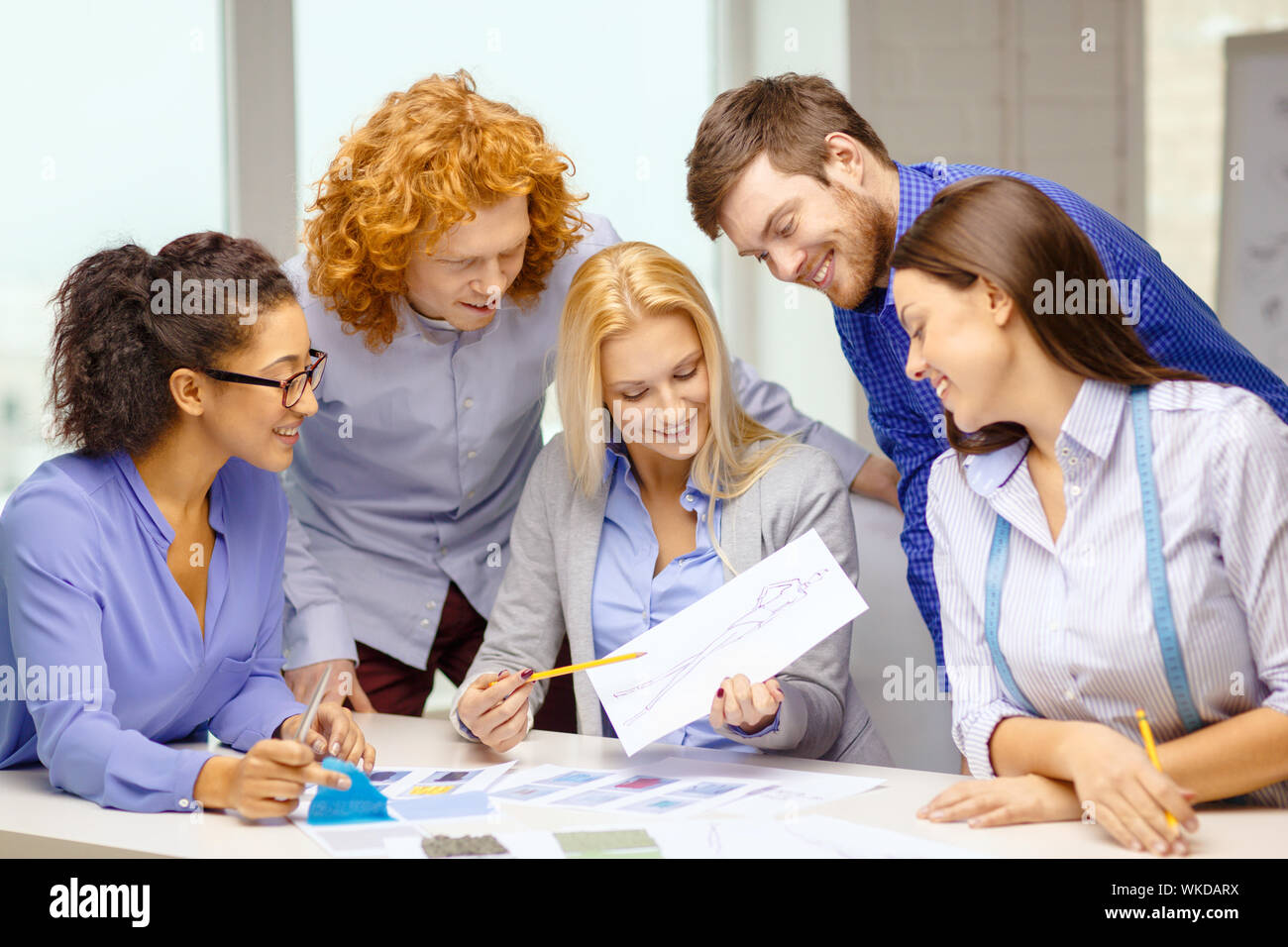 Sorridente team creative guardando il disegno Foto Stock