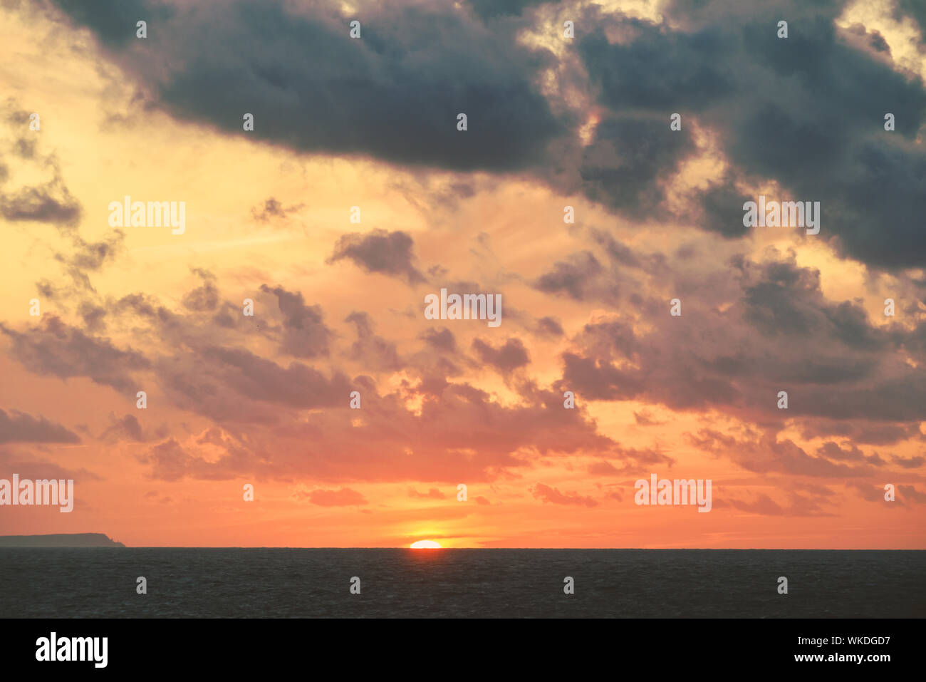 Cielo drammatico con arancione tramonto sull'oceano paesaggio costiero scena sull acqua Foto Stock