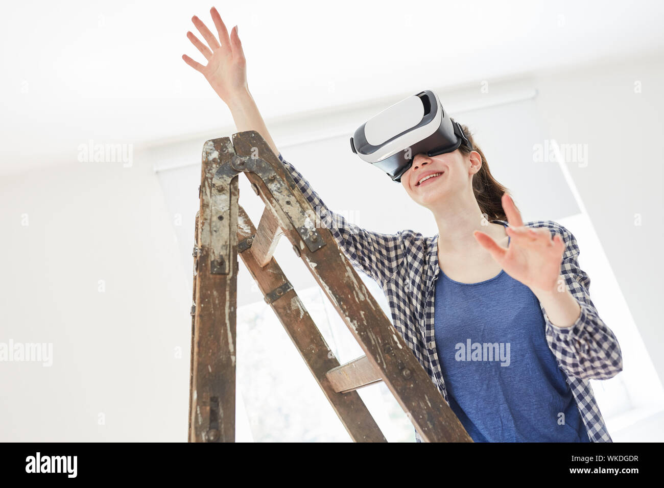 Giovane donna rinnovando con occhiali per realtà virtuale immagina i nuovi interni Foto Stock