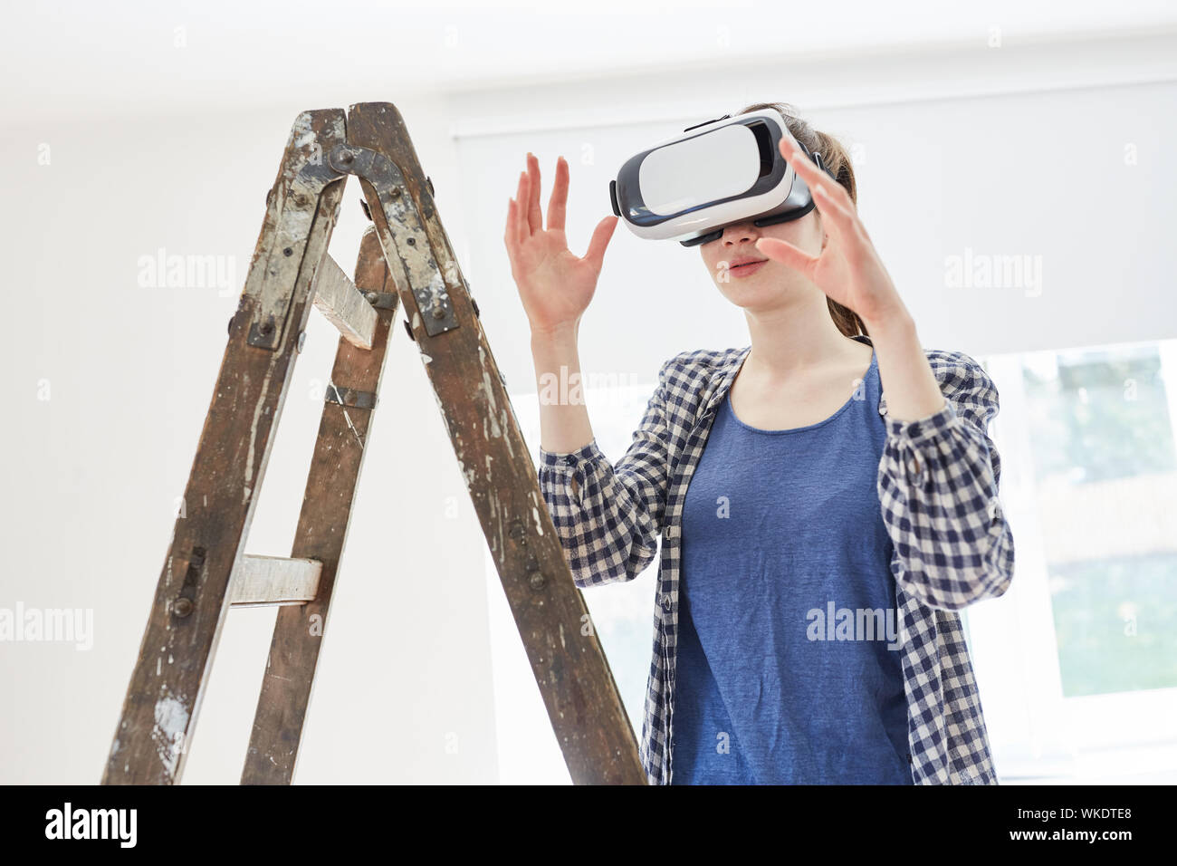 Donna con la realtà virtuale bicchieri al rinnovo immagina nuovi interni Foto Stock